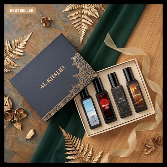 A boxed fragrance gift set from Al-Khalid arranged on a styled surface. The set includes a dark navy branded box, an open cream tray, and four dark bottles with black caps.