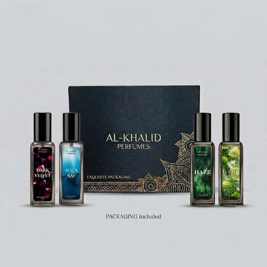 A set of five Al-Khalid Perfumes bottles arranged in front of a black branded box with gold detailing on a light gray background. The set includes Dark Velvet, Aqua Ray, Haze, and Oasis scents, with the text 'PACKAGING Included' below.